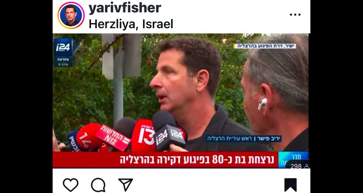 יריב פישר מתראיין לאמצעי התקשורת בזירת הפיגוע בכיכר טיראן בהרצליה פיתוח. המקרופונים של ערוצים 12, 13 14 i24 מול פניו. הצילום מתוך חשבון האינסטגרם שלו
