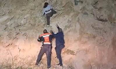 נערה נחלצת בגלישה ממצוק הכורכר בנתניה. שני מחלצים תומכים בה