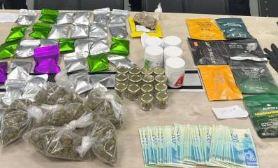 סמים שנתפסו במחסום בהרצליה. על שולחן מונחות שקיות שקופות ושקיות צבעוניות עם חומר חשוד. לידן מונחים שטרות של 200 שקלים, כפפות, טלפונים סלולריים, מפתחות וקופסאות עם חומרים.