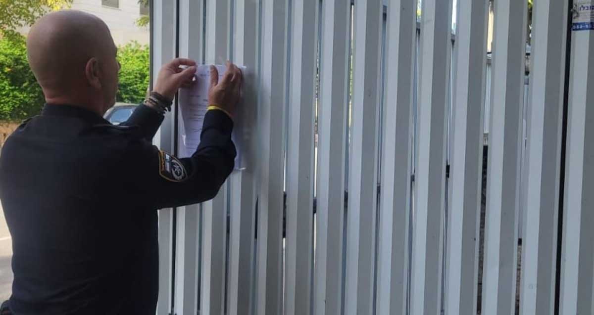 שוטר מדביק על גדר צו סגירה מנהלי למשך 30 יום לגן ילדים בכפר סבא