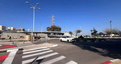 תחנת הרכבת הרצליה. בצד ימין כיכר ומכונית לבנה. בצד שמאל מעבר חצייה להולכי רגל של שני מסלולים. ברקע גשרים להולכי רגל