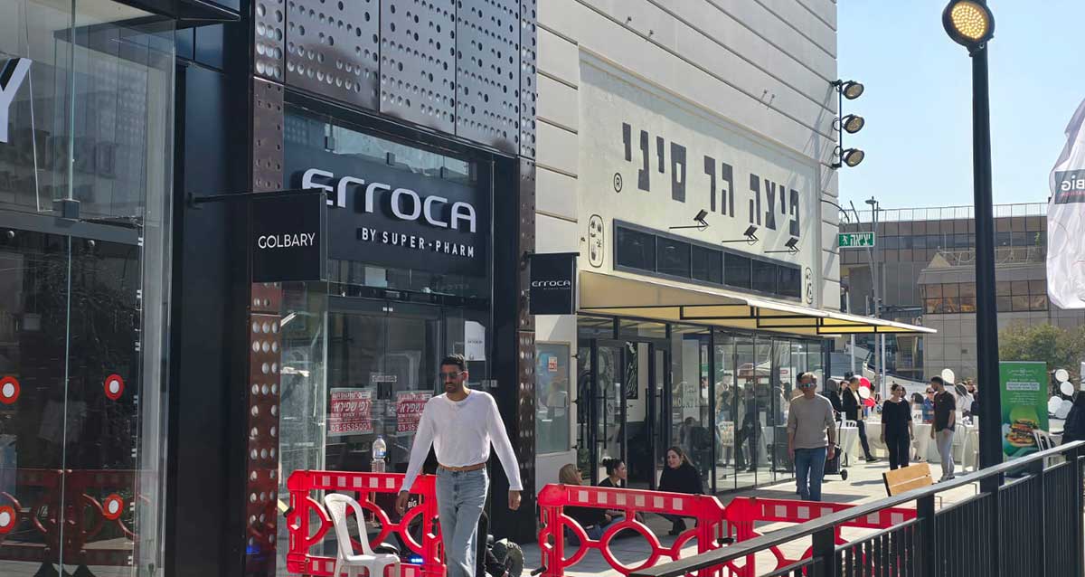 ביג פאשן גלילות, היערכות לפתיחה הגדולה. החנות של אארוקה ופיצה הר סיני, אנשים הולכים במדרכה ליד ומחסומים אדומים