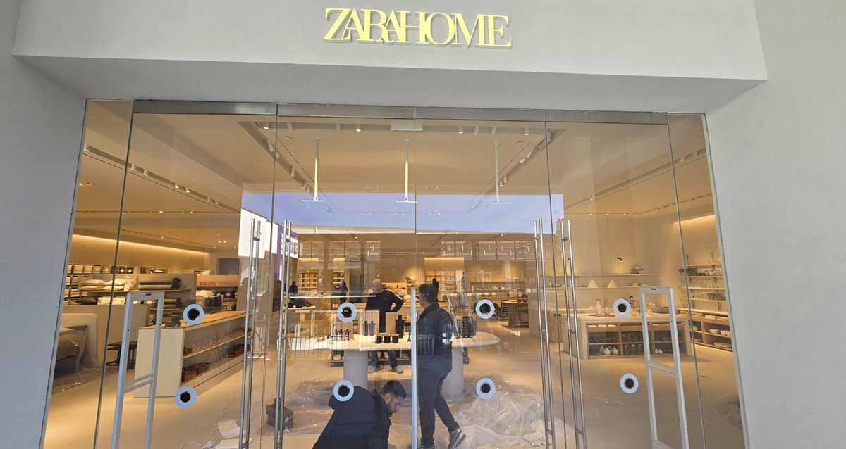 ביג פאשן גלילות - הכנות אחרונות לפתיחה. תמונה של הכניסה לחנות של זארה ואישה בפנים החנות. מעל הכניסה שלט באנגלית: ZARAHOME