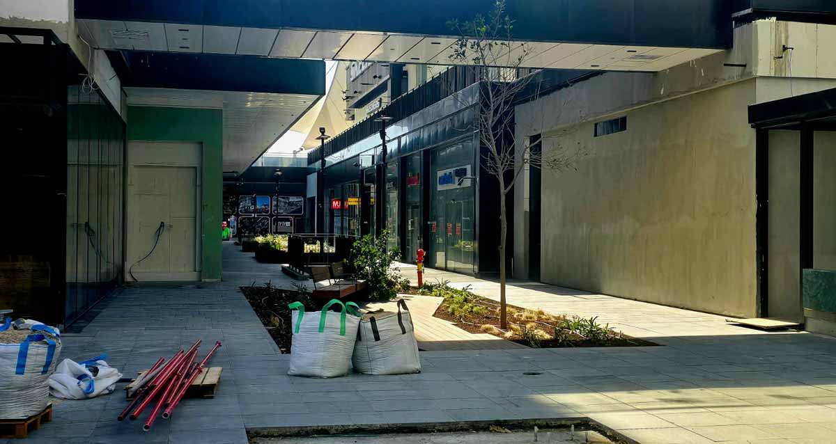 מתחם ביג גלילות רגע לפני הפתיחה. שורת חנויות בצד ימין בתוך הקניון. באמצע מדרגות ירידה לחניון וערוגות של צמחים. על החנות הראשונה כיתוב באנגלית: CARTER'S. חומרי בנייה בשקים בצד שמאל.