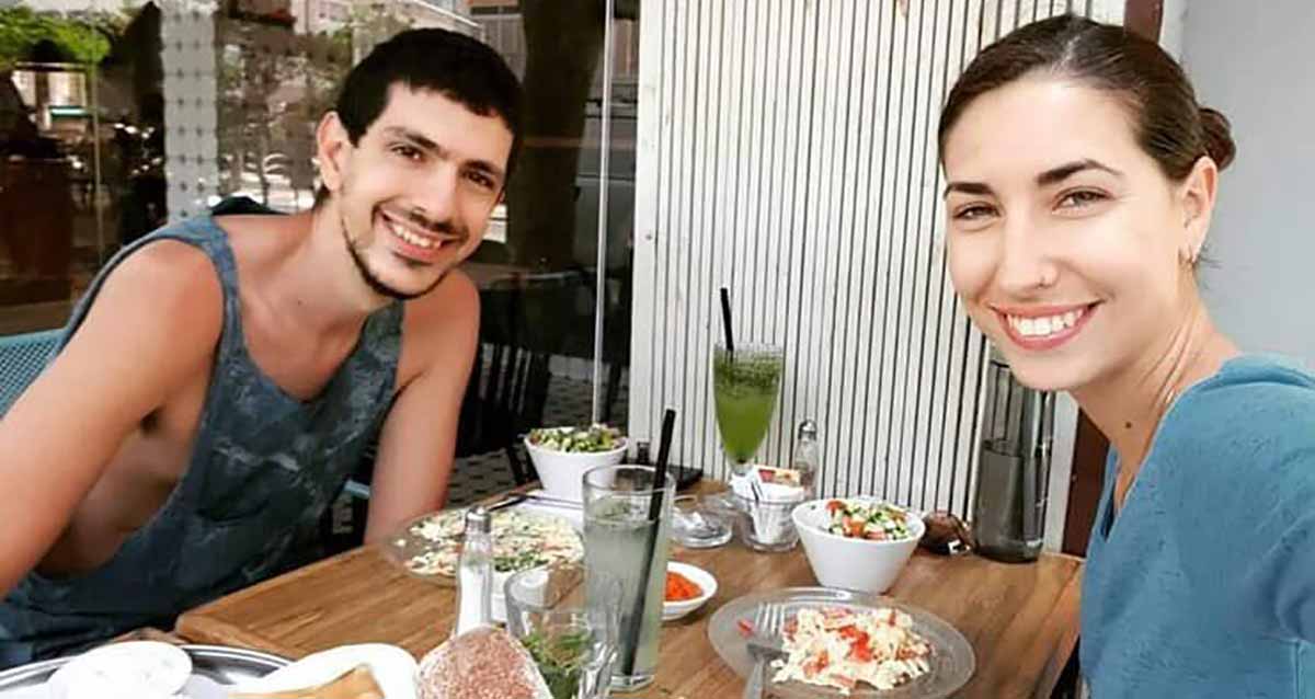 מיזם עוגיות לזכרה של עינב ז"ל אשתו של אור לוי. תמונה של עינב ז"ל ושל אור ליד שולחן עם צלחות מאכלים ושתייה.