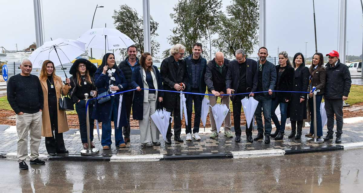 טקס חנוכת רובע 10. צילום: עיראיציק רוכברגר גוזר את הסרט הכחול בטקס חנוכת רובע 10, לצידו אנשים נוספים. חלקם מחזיקים מטריות