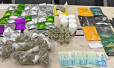 הסמים שנתפסו בהרצליה. על שולחן מונחות שקיות עם סמים, קופסאות עם סמים, שטרת של 200 שקלים, כפפה, מפתחות וטלפונים.