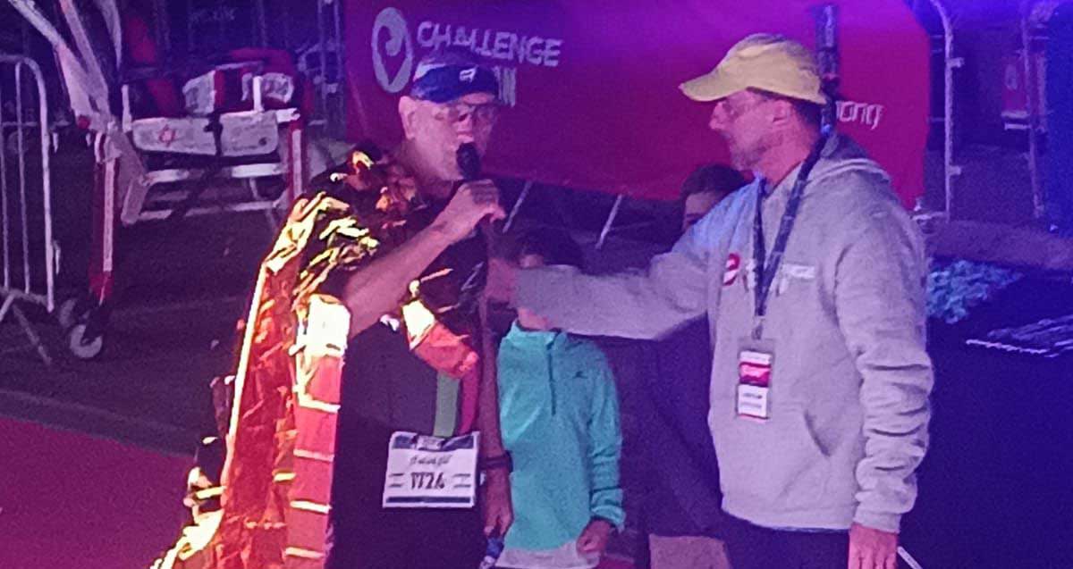 אלי בלאלי אוחז מיקרופון ולידו מארגן התחרות ושני ילים