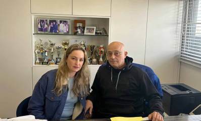 רואי החשבון יפתח גסר ושי גסר יושבים במשרד ליד שולחן. מימין מדפסת. מאחוריהם בתוך הקיר שקע עם גביעים ותמונות.