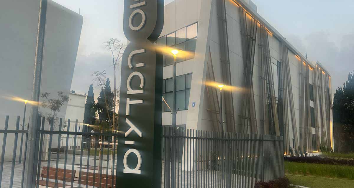 התיכון למדעים הרצליה. בניין של שלוש קומות, צילום של פינת הבניין הארוך. על גדר התיכן שלט עם הכיתוב: קמפוס המדעים.