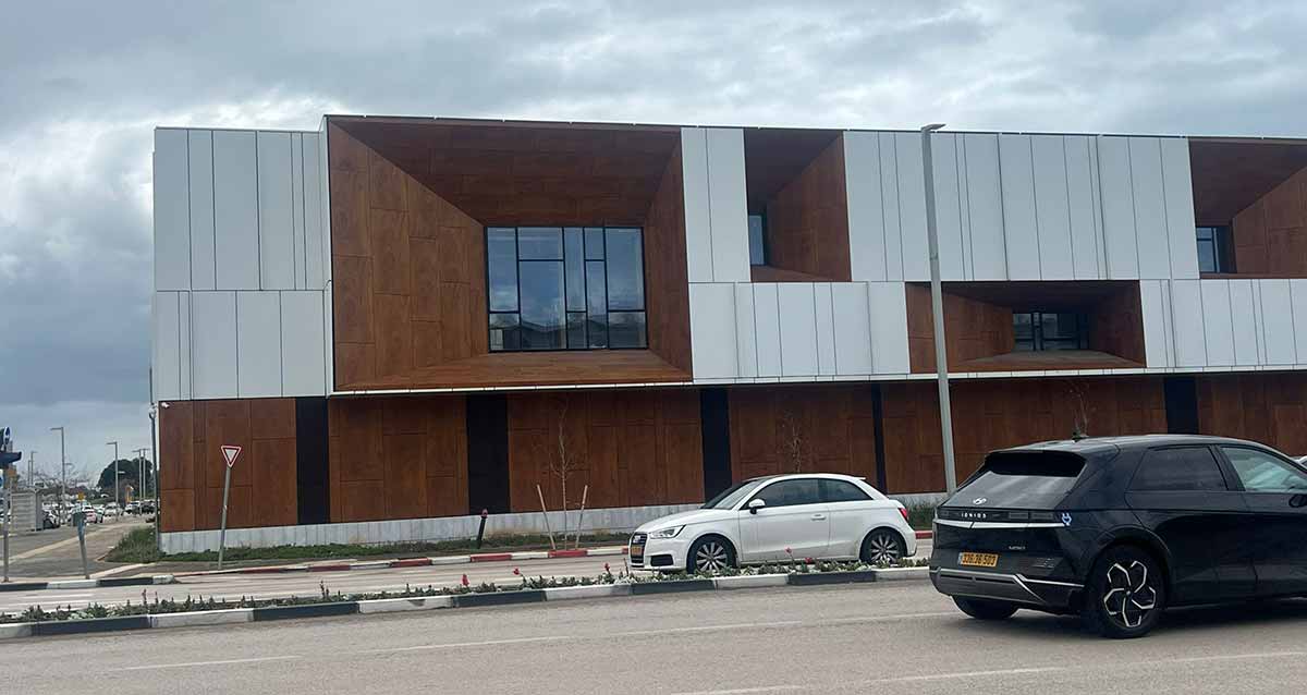 קריית חינוך הנשיא שמעון פרס בשכונת גליל ים. שורת מבנים בצבעים חום ולבן. הקריה בנויה לאורך שדרת שבעת הכוכבים, ושני כלי רכב בכביש.