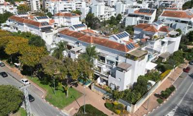 שדרוג שכונת 2004 ברעננה. צילום מגבוה של השכונה בהצטלבות של שני רחובות. השכונה של בתים בני 4 קומות עם גגות רעפים. ברקע בניינים גבוהים.