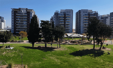 שכונת גליל ים. בתים של עשר קומות ולפניהם פארק עם דשא ומתקן משחקים לילדים.
