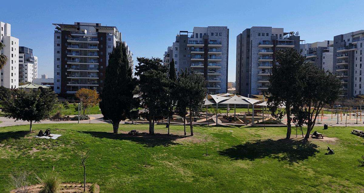 שכונת גליל ים. בתים של עשר קומות ולפניהם פארק עם דשא ומתקן משחקים לילדים.