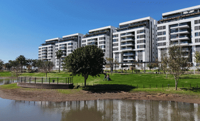 שכונת גליל ים. בתים של עשר קומות ולפניהם פארק עם דשא ובריכה.