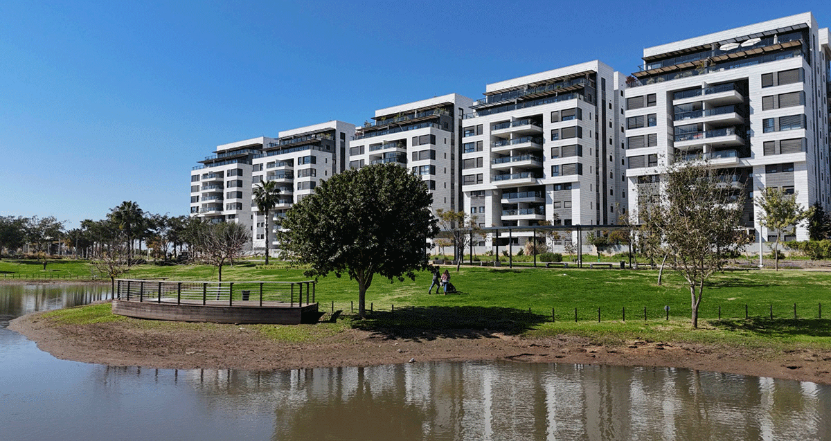 שכונת גליל ים. בתים של עשר קומות ולפניהם פארק עם דשא ובריכה.