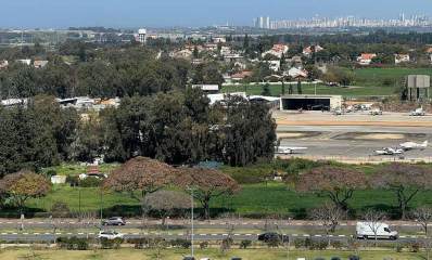 שכונת נחלת עדה בהרצליה. במרכז התמונה שדה התעופה של הרצליה ומעבר לו בתים חד קומתיים של השכונה. ברקע בניינים גבוהים.