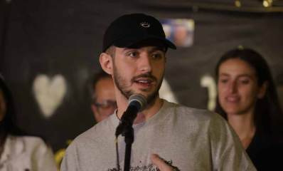 עומר שם טוב מדבר לקהל עם מיקרופון.