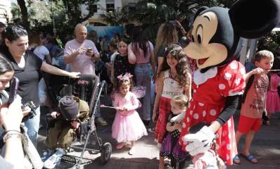 אירוע פורים המרכזי בהרצליה. קהל של מבוגרים וילדים עומד מול אישה מחופשת לדיסני.