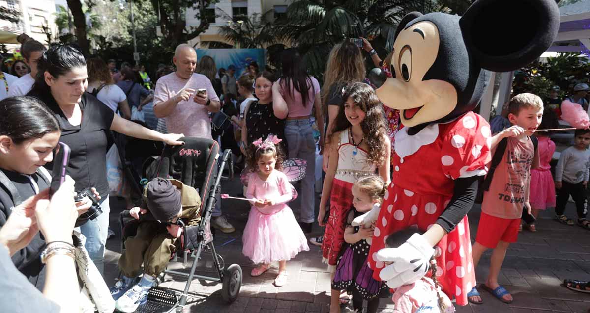 אירוע פורים המרכזי בהרצליה. קהל של מבוגרים וילדים עומד מול אישה מחופשת לדיסני.