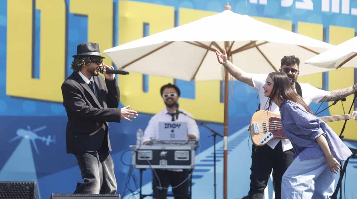 אירוע פורים המרכזי בהרצליה. על הבמה האומנים נס וסטילה ומאחוריהם נגן גיטרה ומפעיל מוזיקה.