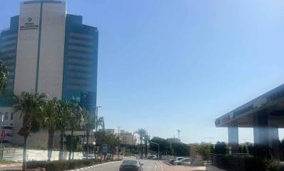 מלון פרימה מילניום באזור התעשייה רעננה בצד שמאל של התמונה. בניין גבוה עם חלק אמצעי בצבע לבן ללא חלונות.