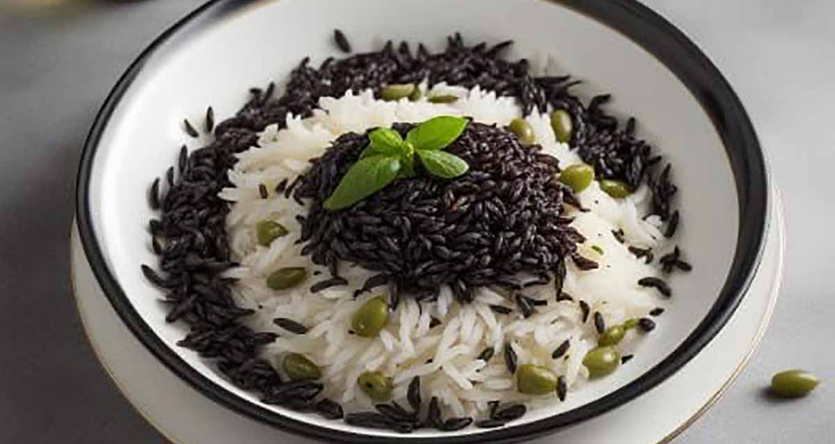 אורז בשני צבעים של שף שאול בן אדרת בקערה. האורז הלבן בתחתית והשחור במרכז ובהיקף הקערה. עלים ירוקים על האורז השחור וזיתים ירוקים מפוזרים.