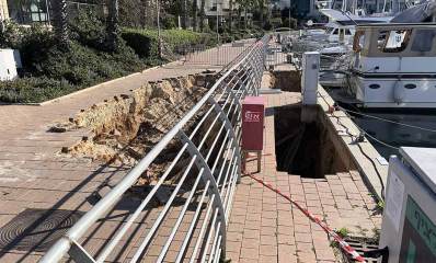 בולען במספנת מרינה הרצליה. בור עמוק ברציף. בצד שמאל ארון כיבוי אש בצבע אדום, ומאחוריו מעקה מתכת, ואחרי המעקה בור במדרכה. בצד ימין סםינות.