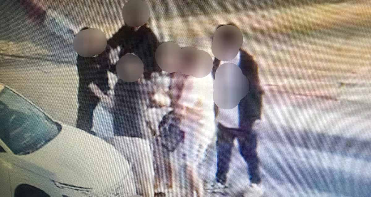 אלימות בכבישי הרצליה. ליד מכונית בכביש קבוצה של אנשים עומדים צמודים, וזהותם מטושטשת.