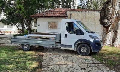 שיפוצים בלשכת ראש העיר כפר סבא. טנדר עם ציוד חונה לפני הבית החד קומתי עם גג רעפים.