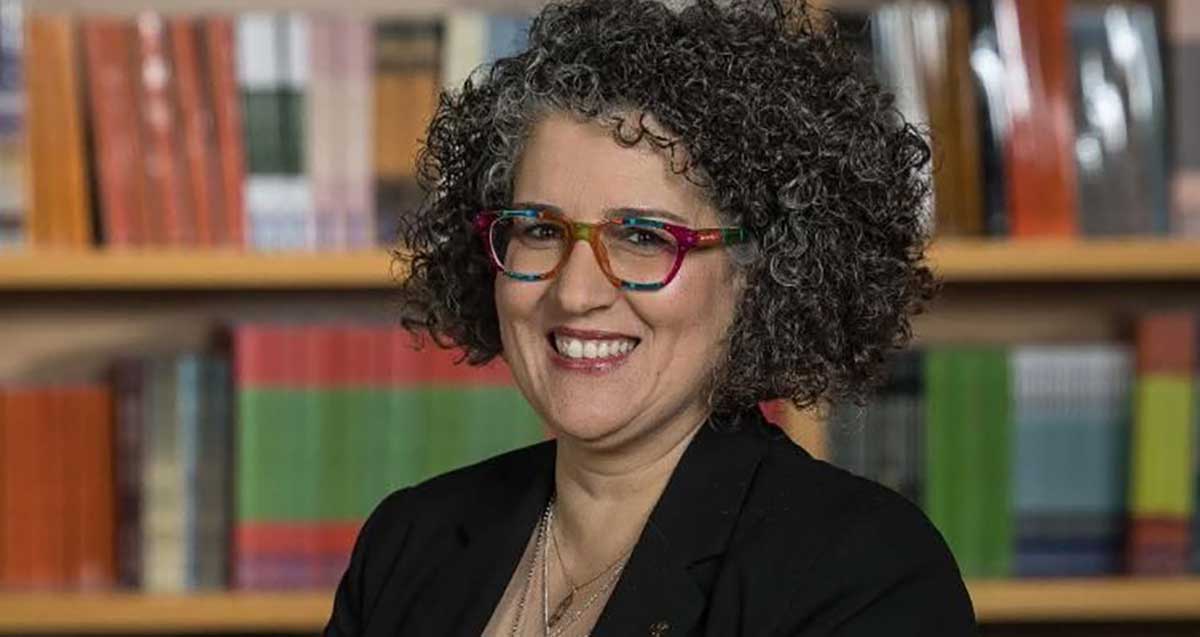 אפרת אברהם ליבנה, מרכיבה משקפי ראייה, עם בגד שחור ושרשראות על הצוואר.