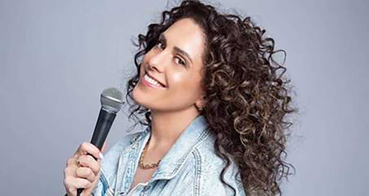 הזמרת חגית גינזבורג אוחזת במיקרופון