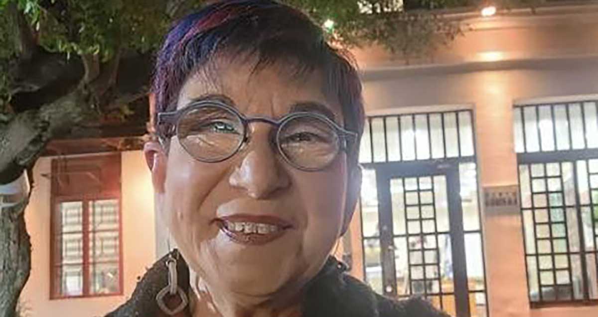 לירית שפיר שמש חברת מועצת עיריית כפר סבא מסיעת מרצ. צילום פנים, מרכיבה משקפי ראייה. ברקע בניין עם חלונות גדולים.