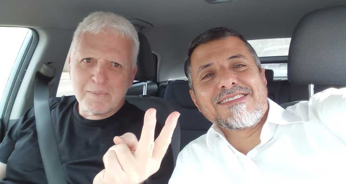 רמי נבון, מסמן וי באצבעות, וזכי טיירי, שניהם בתוך רכב.