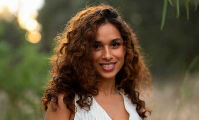 שני כהן עם שיער חום מתולתל.