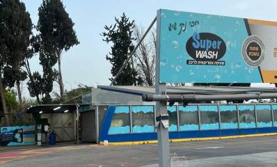 העסק לשטיפת מכוניות בשדרות שבעת הכוכבים בהרצליה. תמונה של מבנה השטיפה כאשר הוא סגור. שלט גדול לפני העסק ושמו באנגלית: Super WASH. ובעברית כיתוב: הכי נקי שיש, פתוח בשבת.