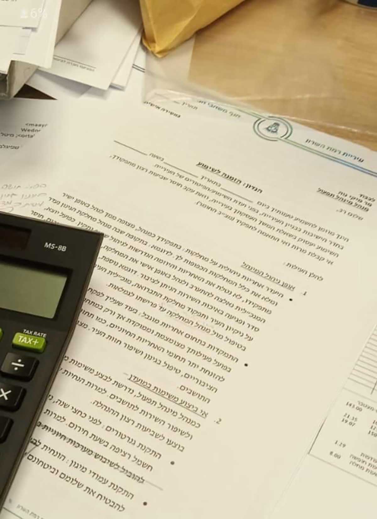 טיוטת הזמנה לשימוע שהוכנה ולא נשלחה לסמנכ"ל עיריית רמת השרון, ללא יום ותאריך. על הטיוטה מונח מחשבון.