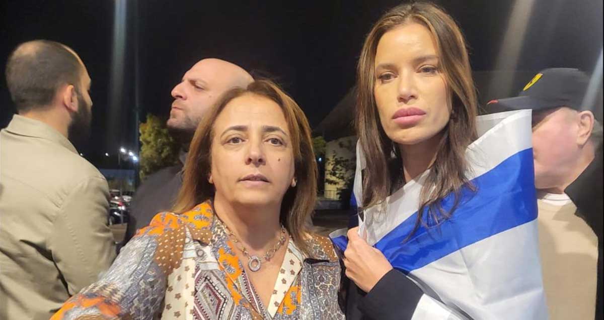 רחלי בן ארי סקעת בהפגנה ברעננה עטופה בדגל המדינה.