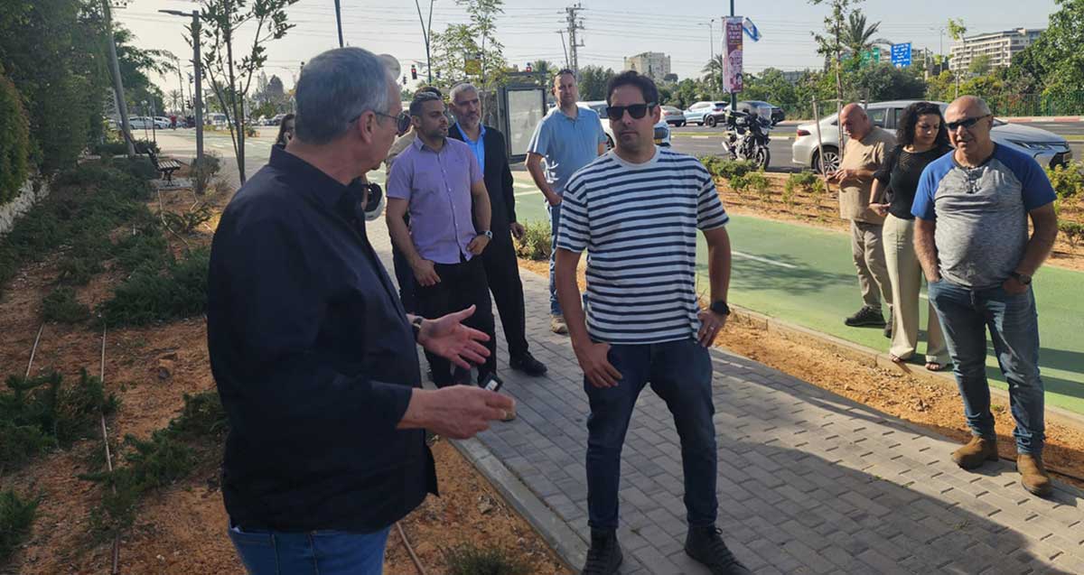 רוכברגר ועובדי אגף התפעול של עיריית רמת השרון ברחוב השרף עומדים על המדרכה ומסתכלים על ראש העיר.