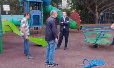 רוכברגר וקורצקי לא משחקים. שניהם ועוד עובד עומדים במרכז גן משחקים.