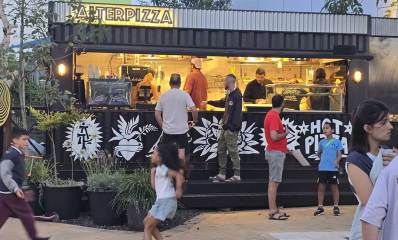 הפיצריה ליד המרכז הקהילתי מטאור ברחוב נתן אלתרמן הרצליה. לקוחות ליד המדרגות של הפיצריה. מעל העסק שלט באנגלית: ALTERPIZZA