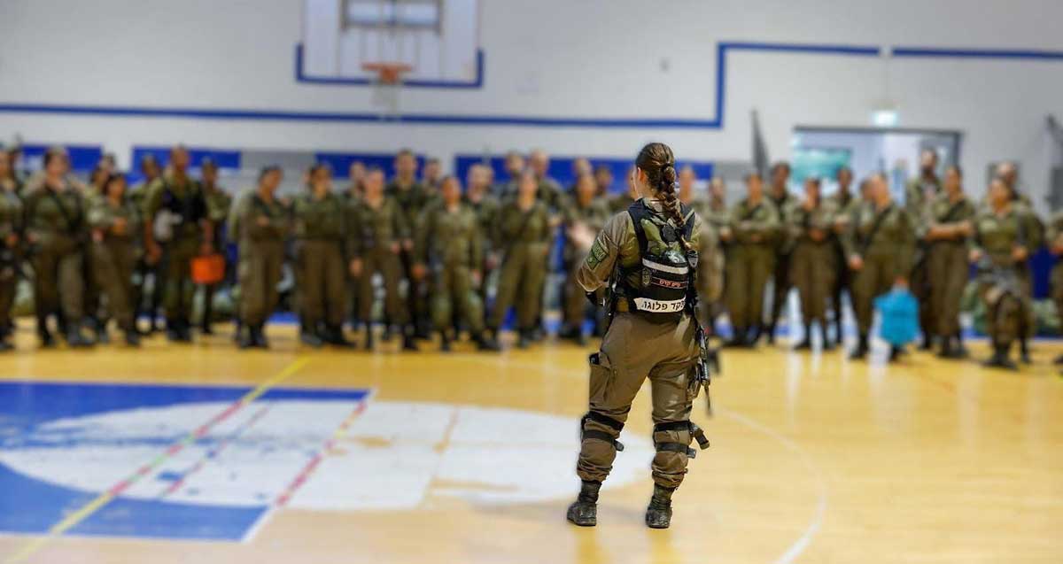 סרן אור מפקדת פלוגת פיקוד העורף בהוד השרון, עומדת באולם ספורט לפני חיילות וחיילי הפלוגה.