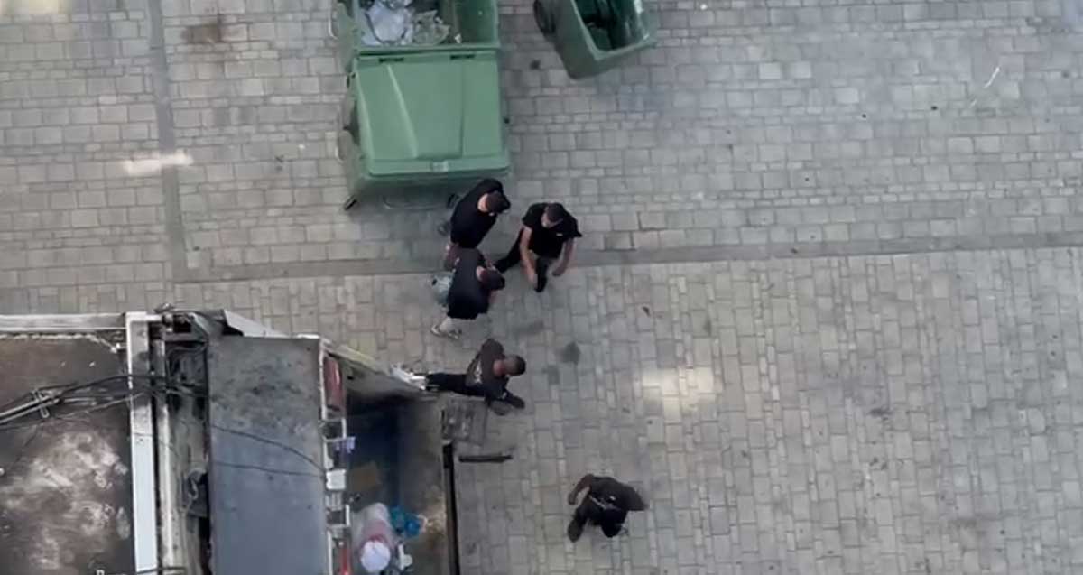 בעל אופנוע אוחז בקסדה ומתעמת עם אנשי הפינוי של האשפה ליד רכב הפינוי בהרצליה