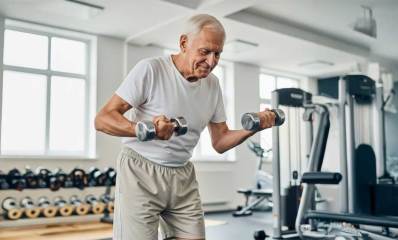 התעמלות וכושר בגיל השלישי. איור של איש מבוגר עם משקולות ביד במכון כושר.