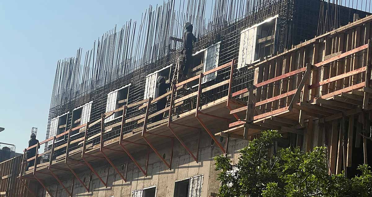 פועל על סולם בגובה רב באתר בניית בית ספר הנדיב