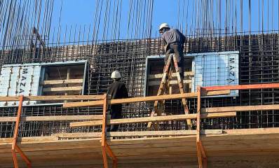 פועל על סולם בעבודת בגובה רב באתר בניית בית ספר