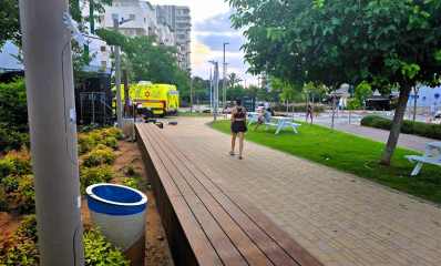 אשה צועדת וניידת מד"א ליד ברחוב נתן אלתרמן. צילום: שרון אונליין