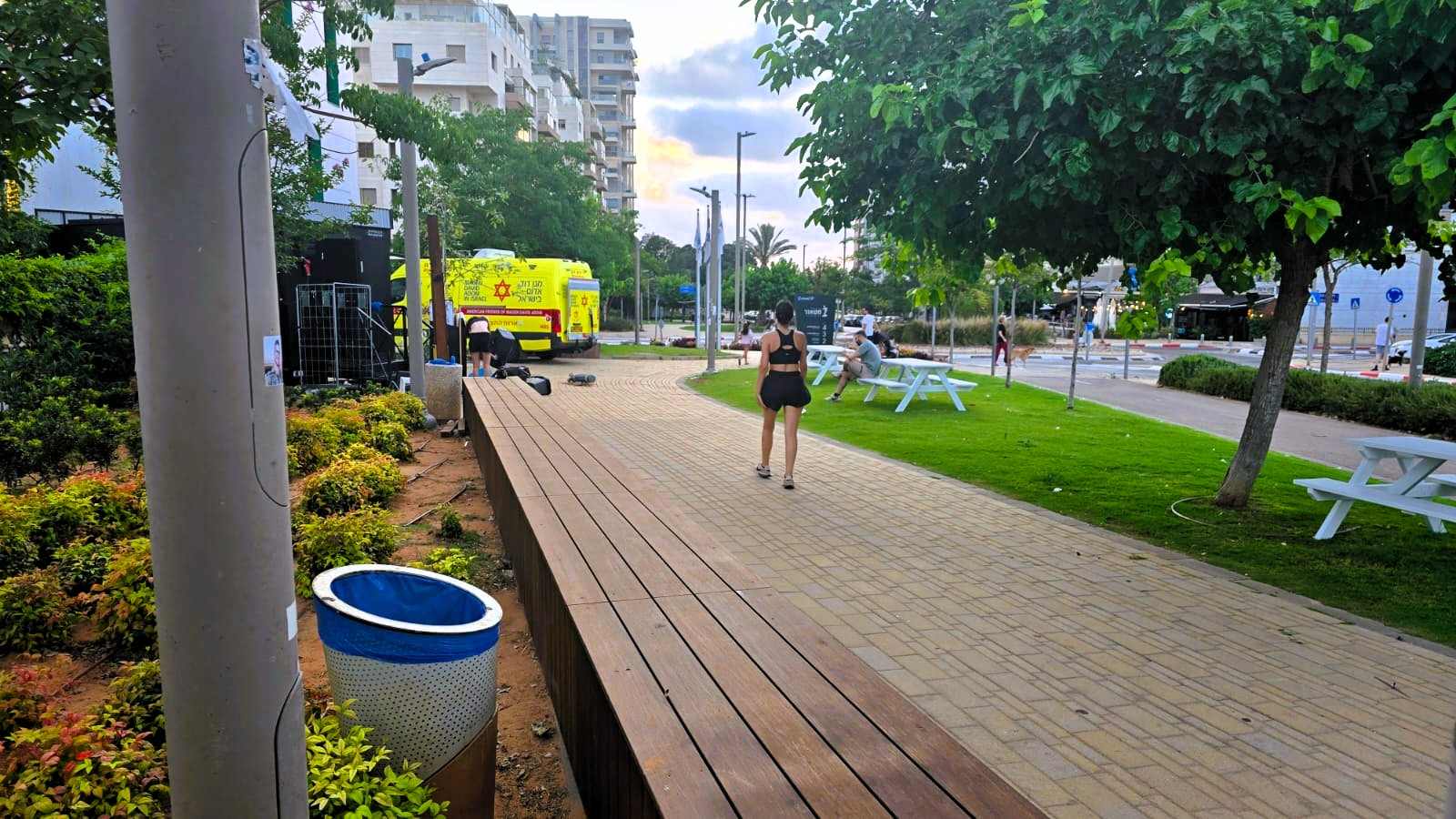 אשה צועדת וניידת מד"א ליד ברחוב נתן אלתרמן. צילום: שרון אונליין