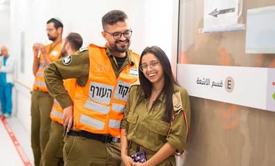 רס"ל ליאל וסרן דניאל במדים. דניאל עם מעיל כתום של פיקוד העורף.