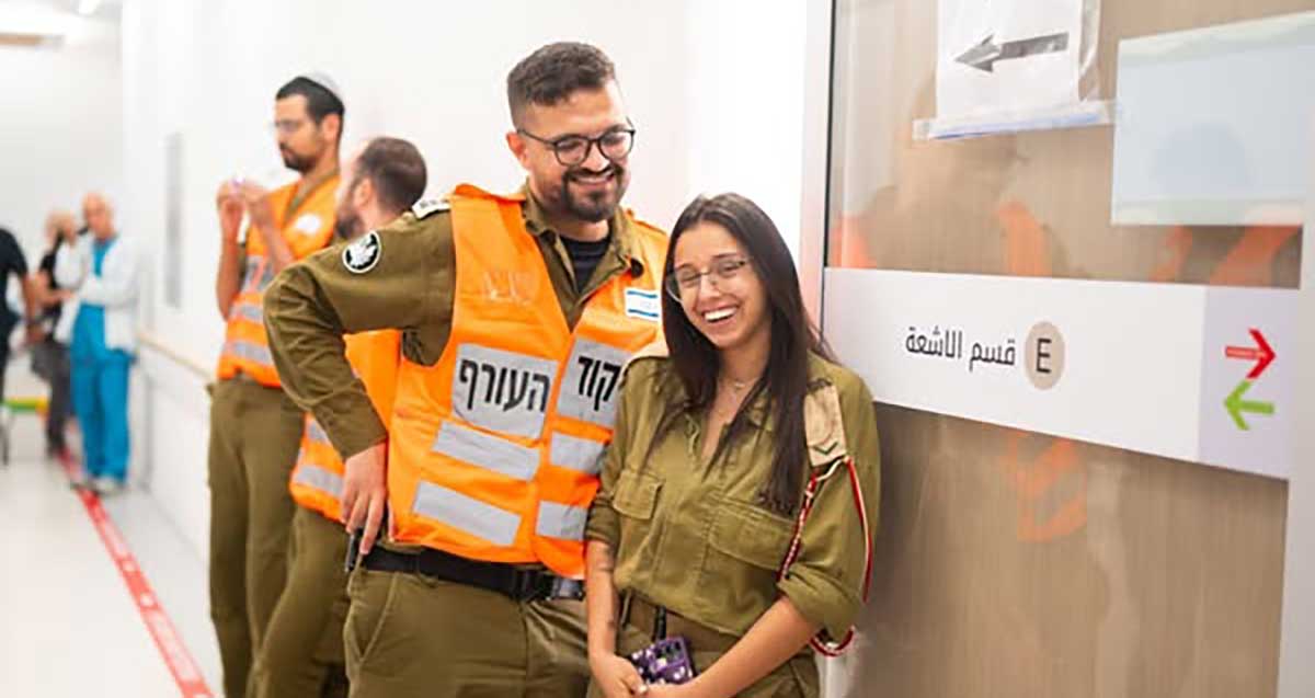 רס"ל ליאל וסרן דניאל במדים. דניאל עם מעיל כתום של פיקוד העורף.